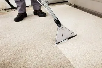 Residential carpet cleaning, a wand pulling a clean stripe through beige carpet.