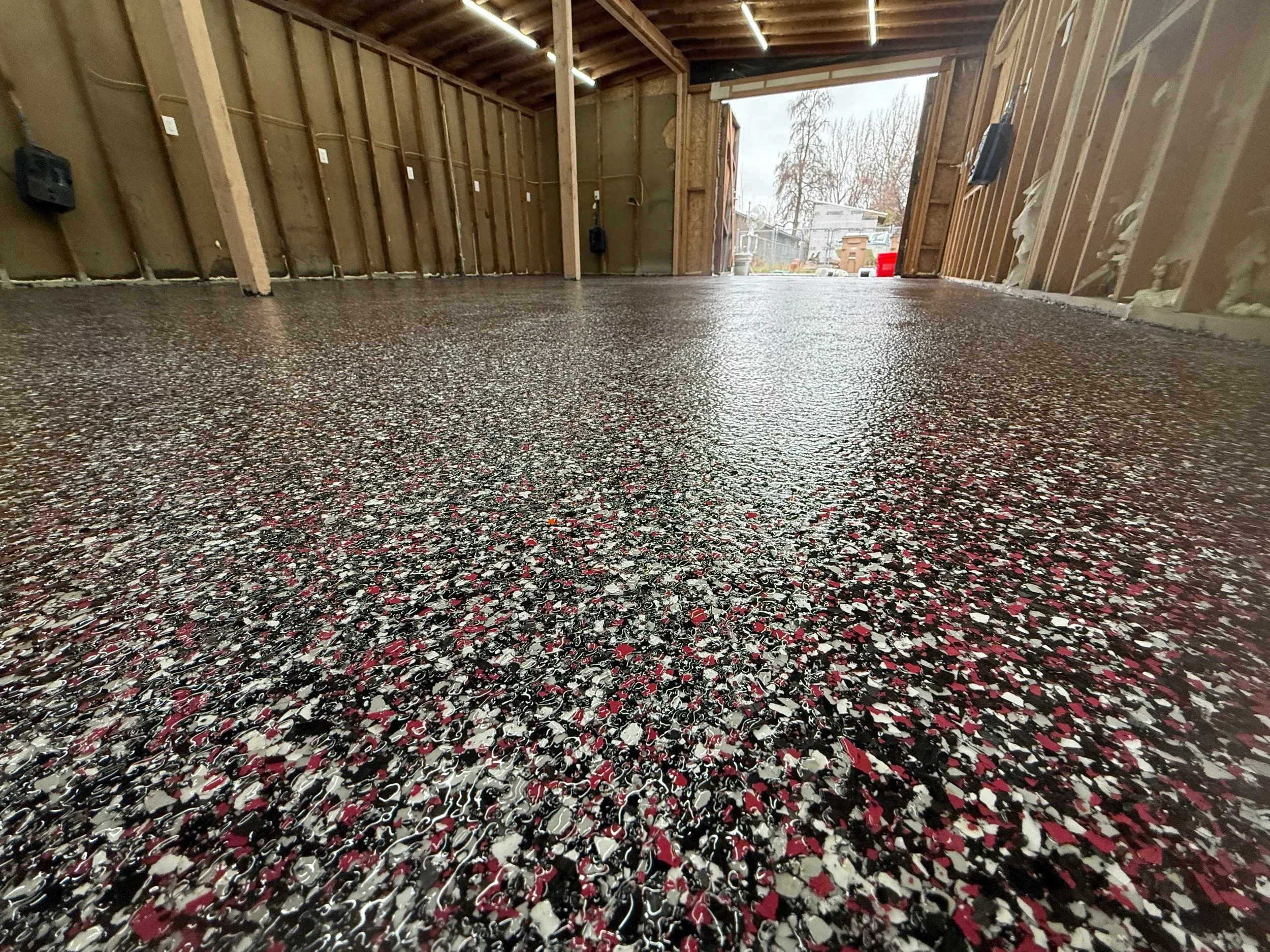 Epoxy floor coating in a garage, a seamless speckled finish over prepared concrete.